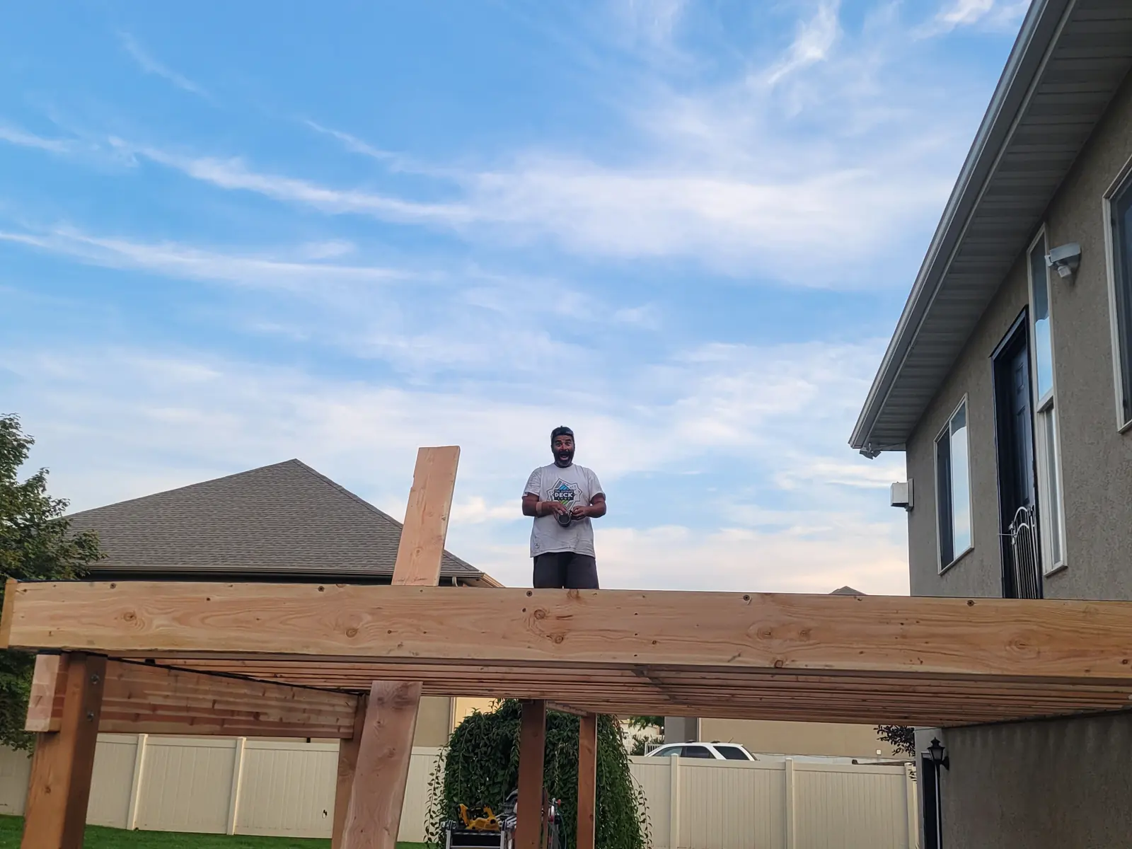 Levi Tippetts standing on the framing of a new second-story deck
