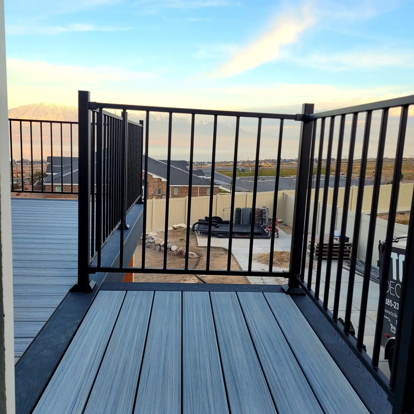 Black aluminum gate at the top of deck stairs