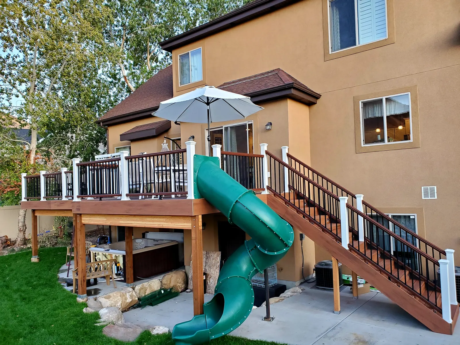 Deck with a green spiral slide and white railing