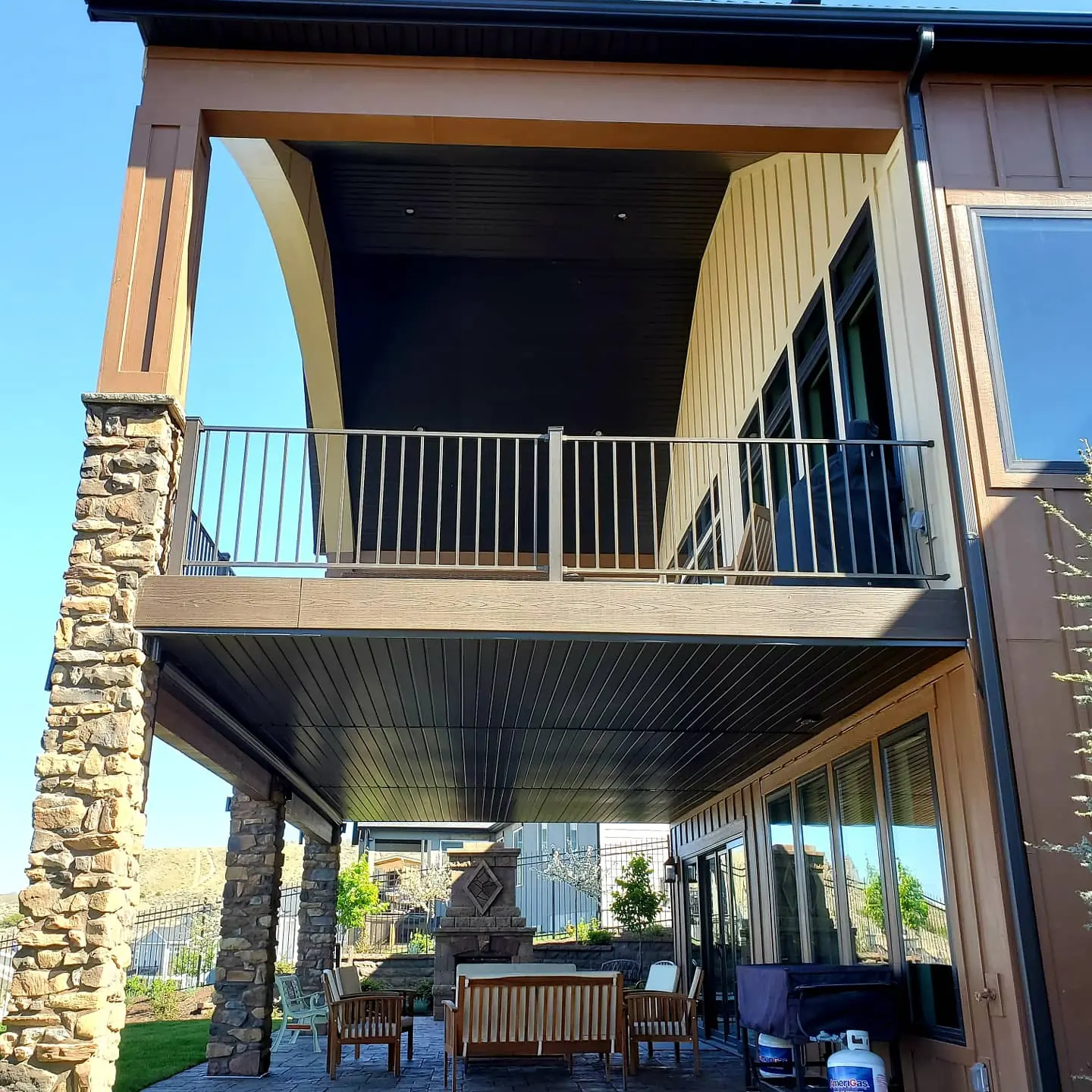Finished ceiling under a second-story deck with stone columns