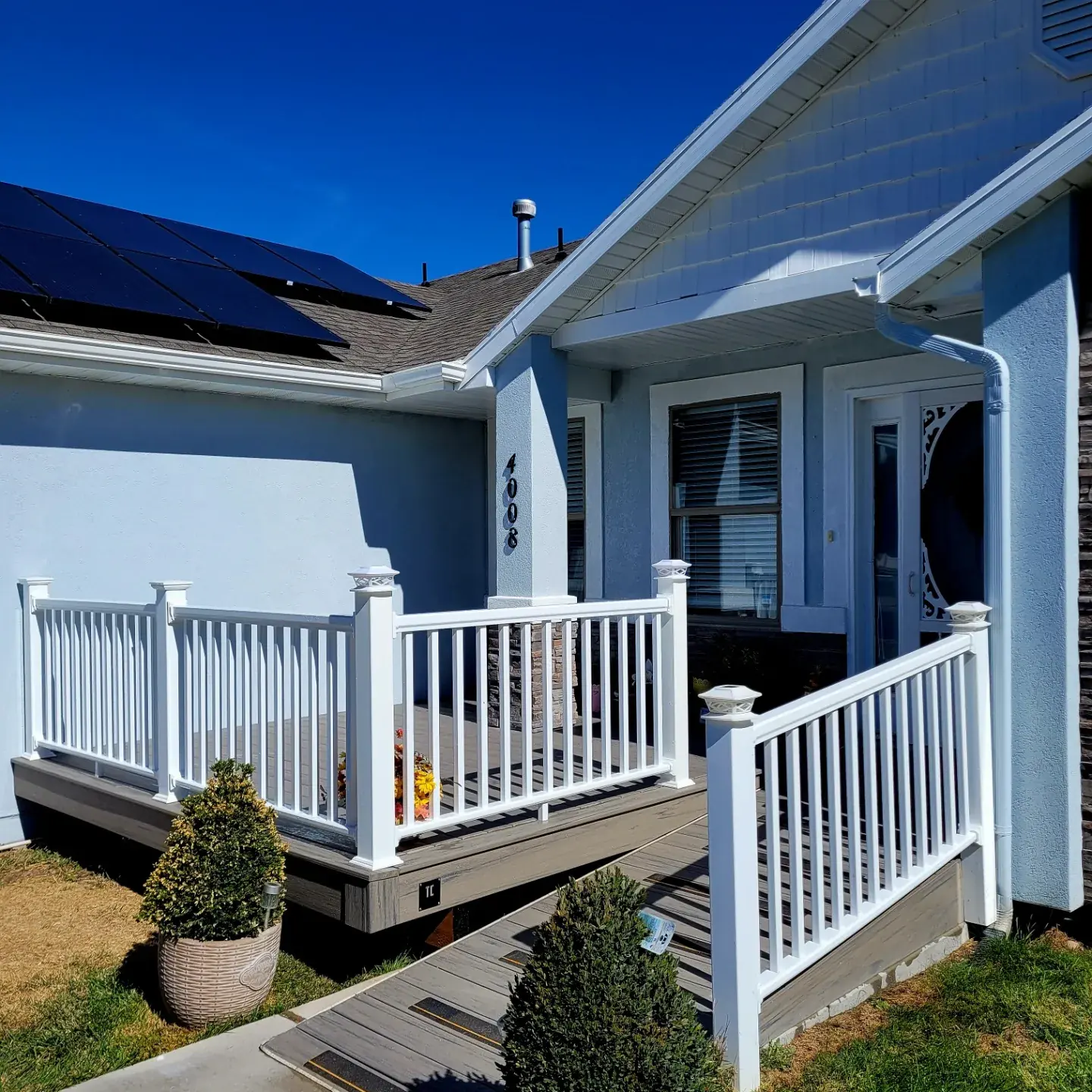 Front porch with white railing and gray composite steps