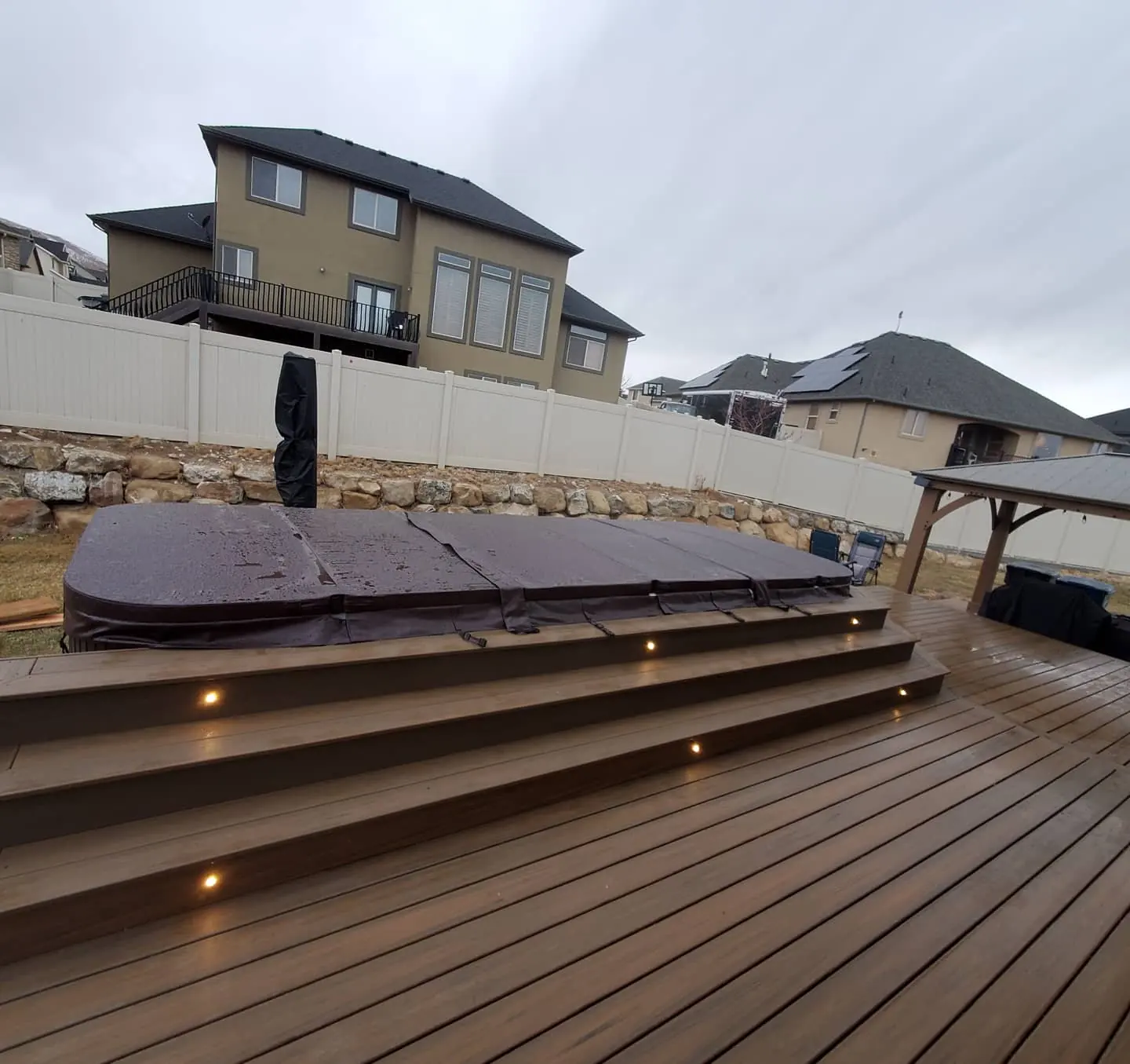 Hot tub framed into a composite deck with wrap-around steps