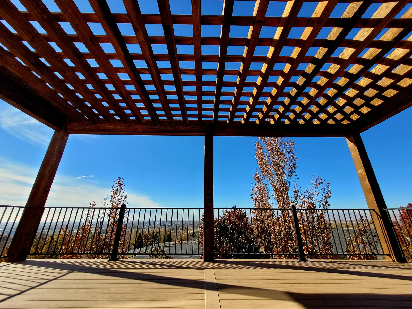 Looking out from under a wood pergola over a composite deck