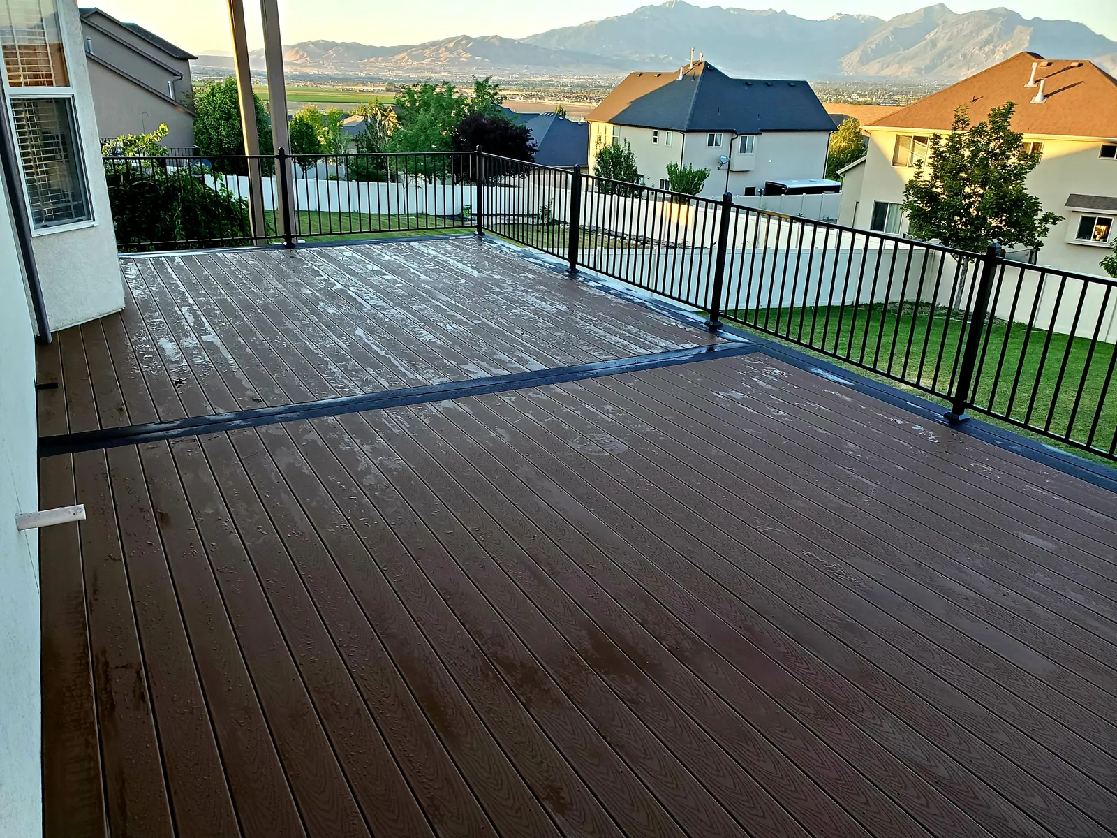 Large two-tone composite deck with black railing and mountain views