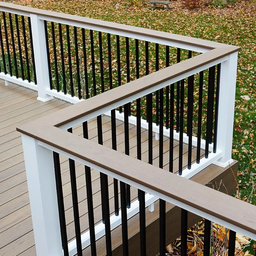 Composite deck corner with white posts, brown top rail and black balusters