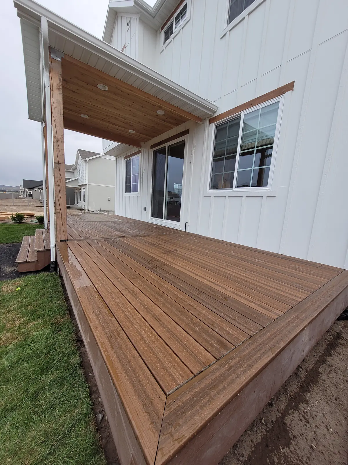 Covered back deck with picture-framed wide steps to the lawn