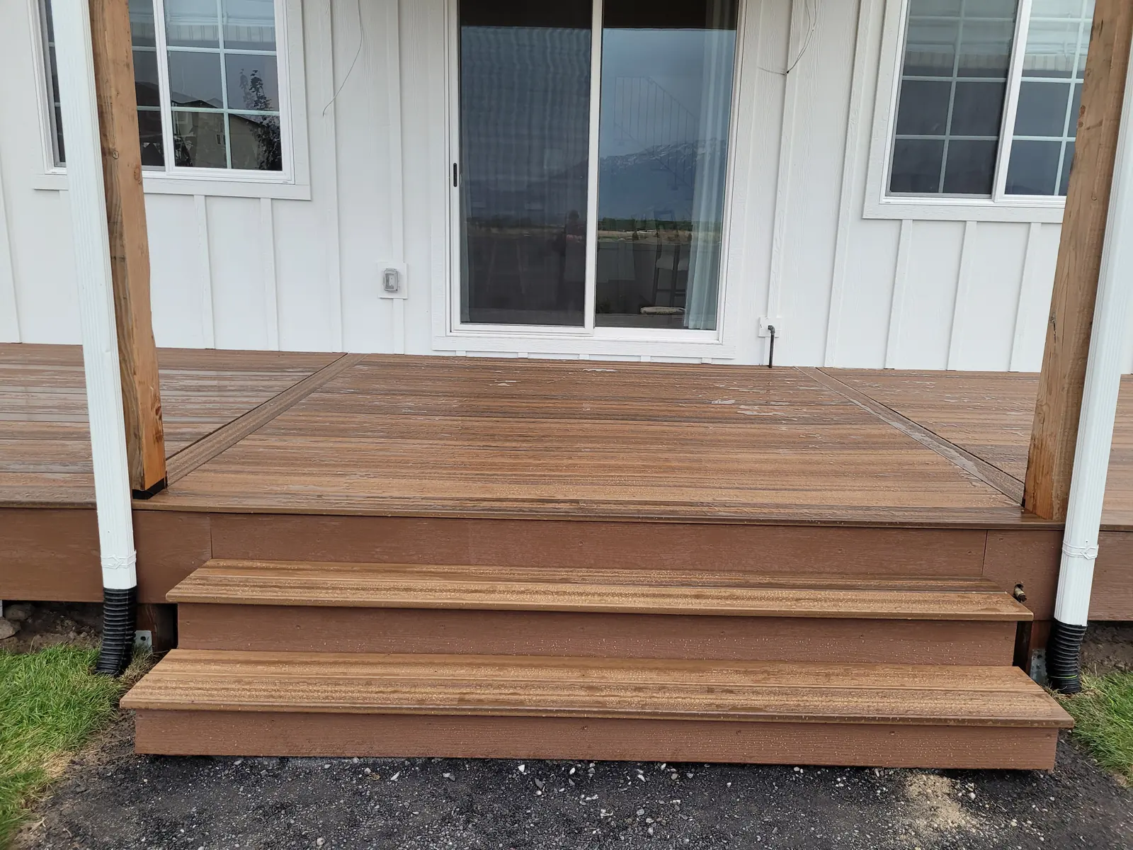 Wide deck steps down to the yard on a new home