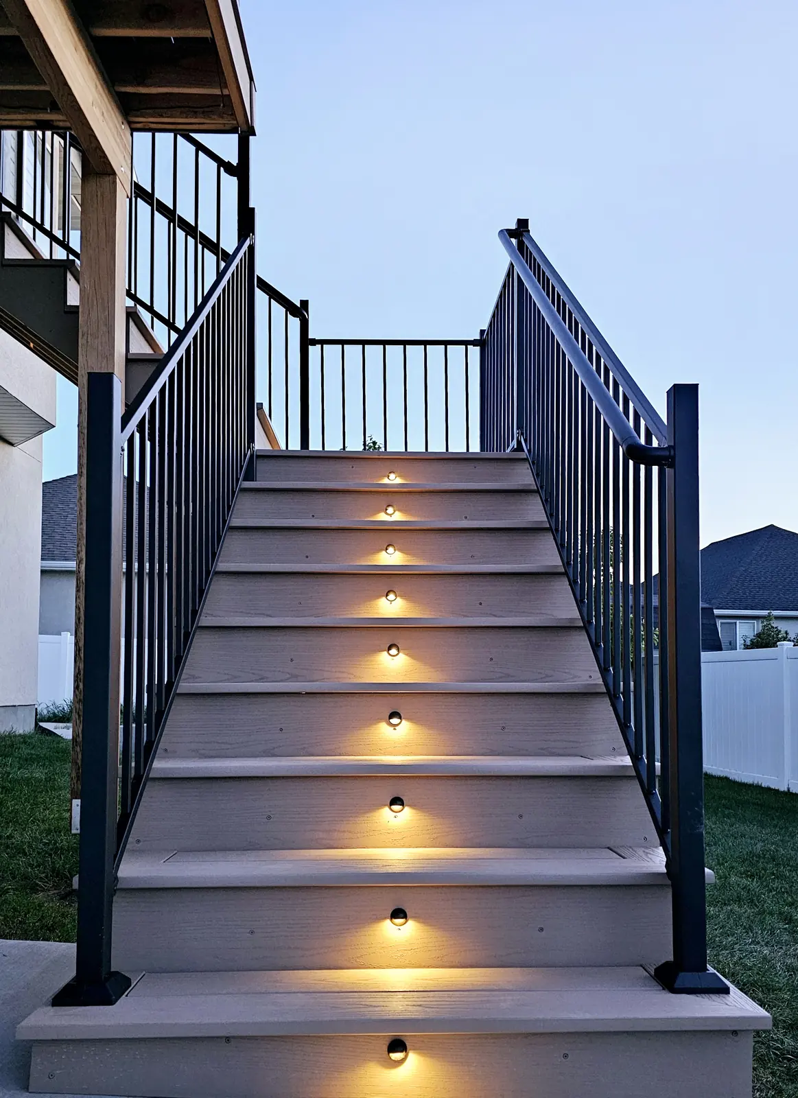Deck stairs with riser lights and black aluminum railing