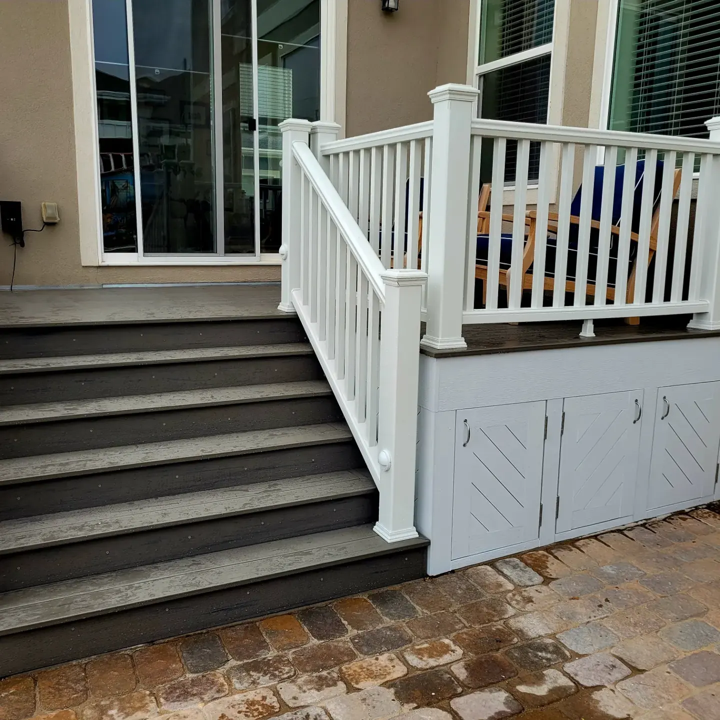 Composite porch stairs beside under-deck storage doors