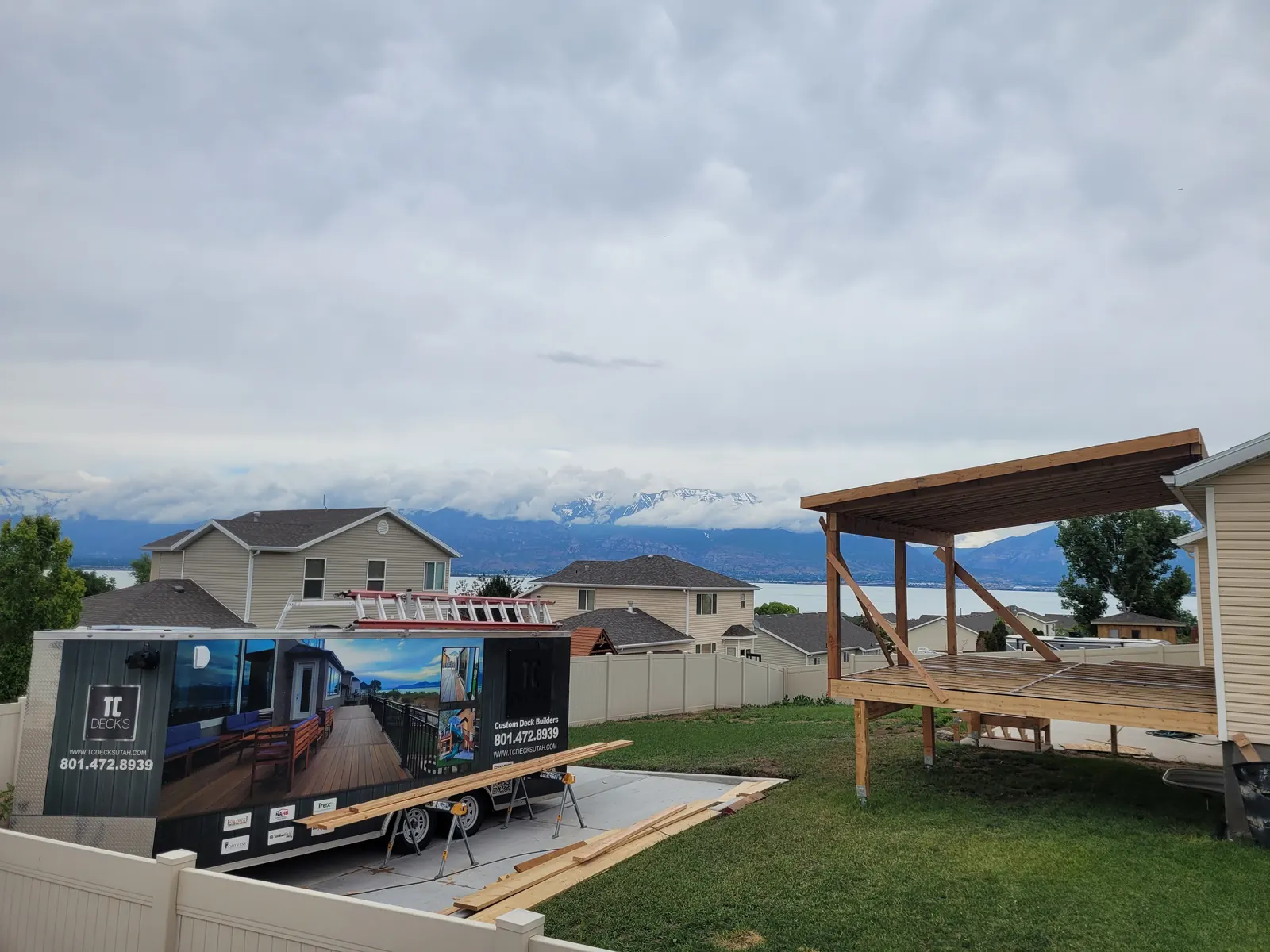 Finished deck roof framing with the TC Decks trailer in the driveway