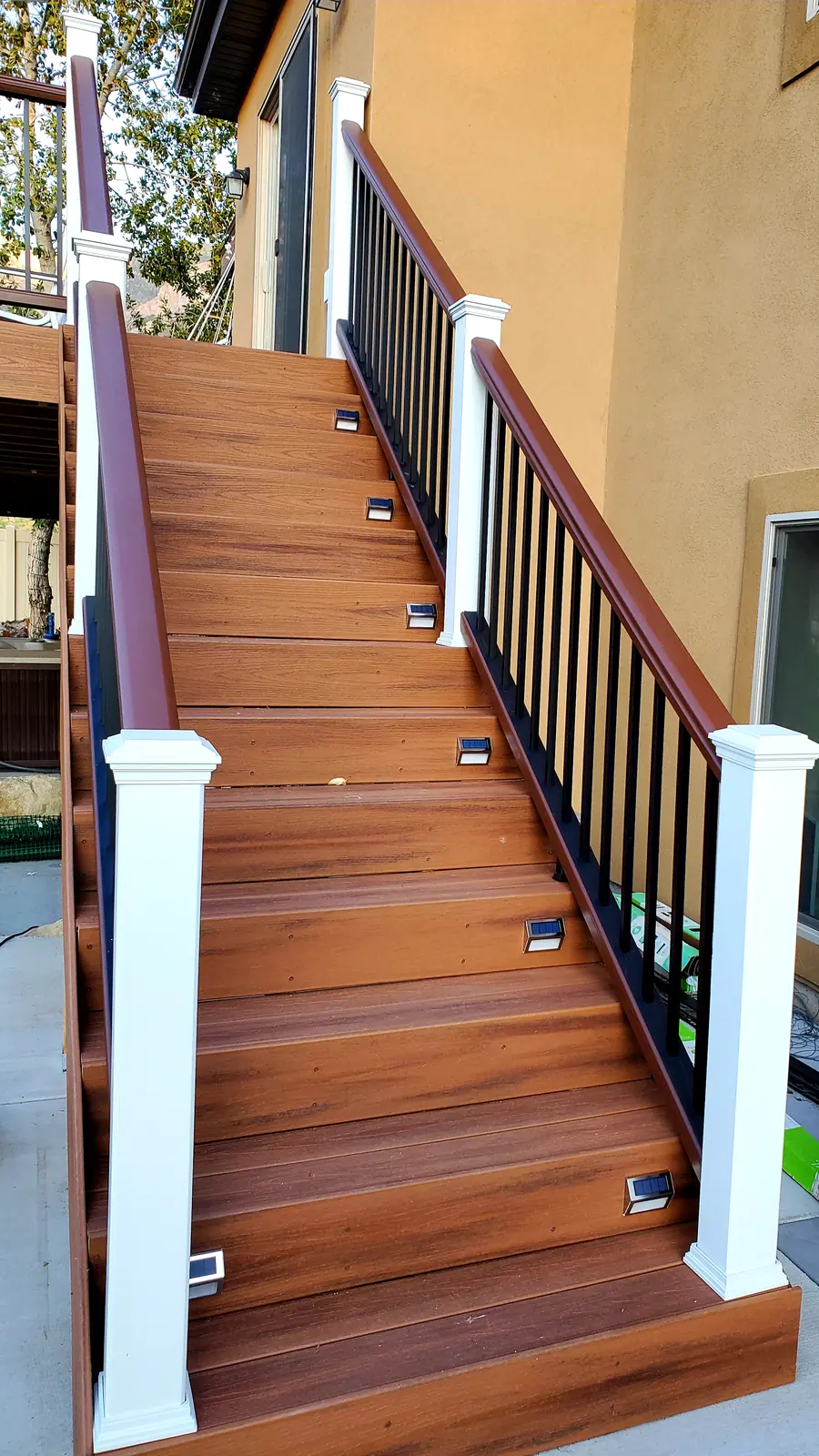 Long composite stair run with white posts and dark balusters