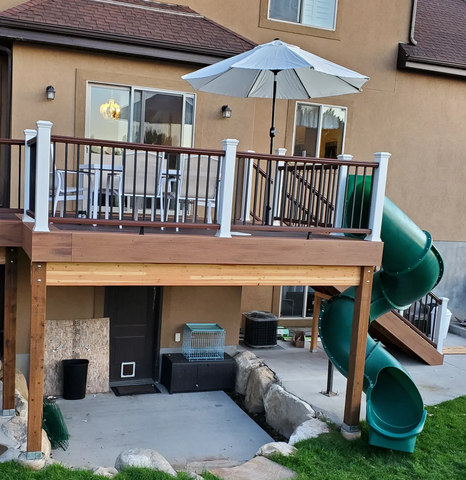 Elevated deck with a tube slide and a covered patio underneath