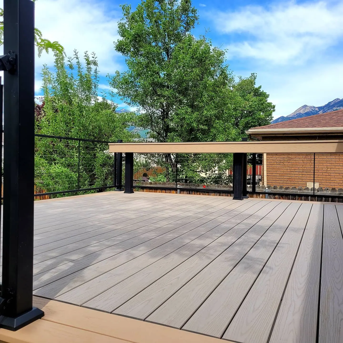 TimberTech Slate Gray deck with a Brownstone border and cable railing below the mountains