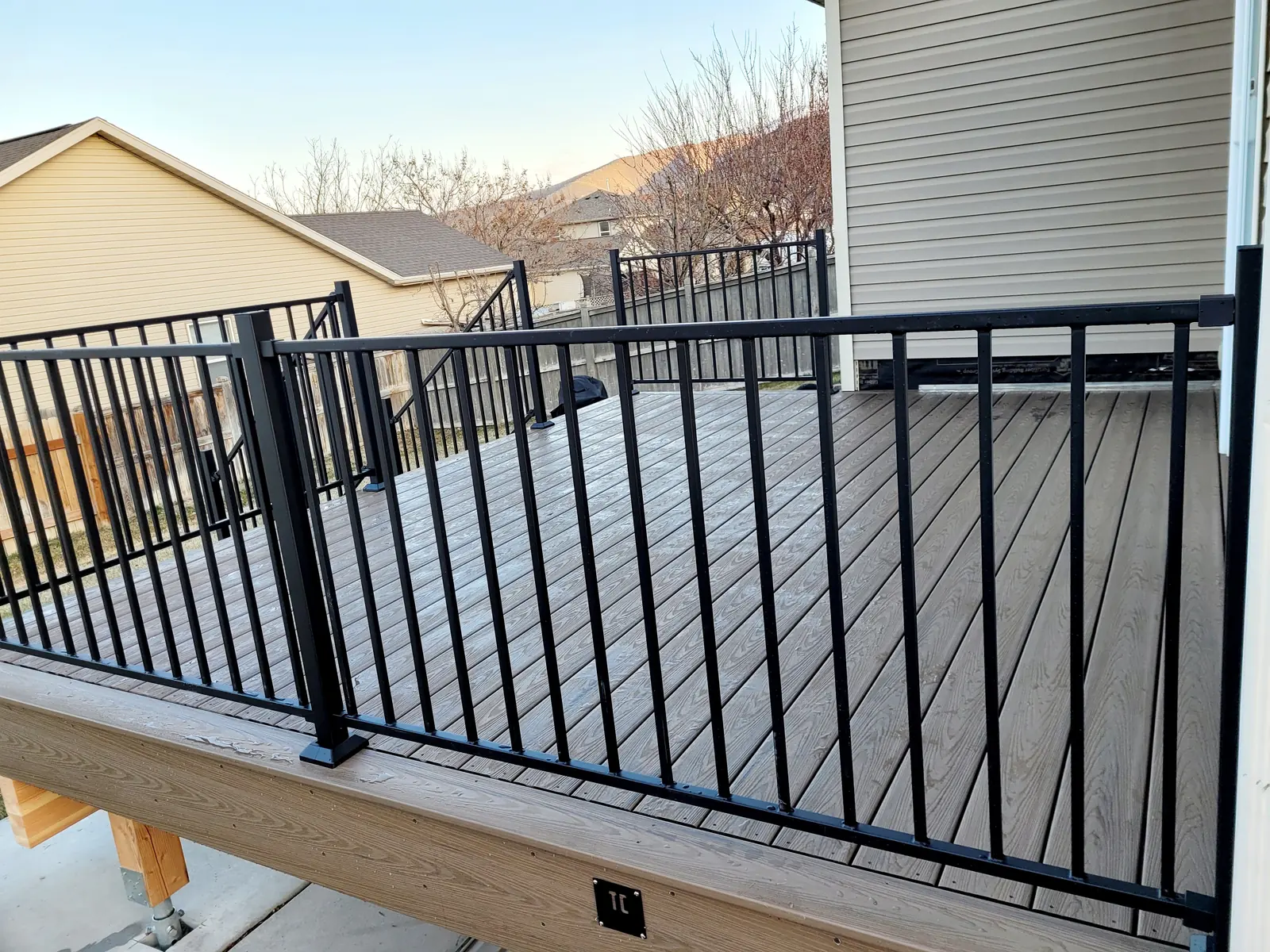 Corner of a composite deck with black railing