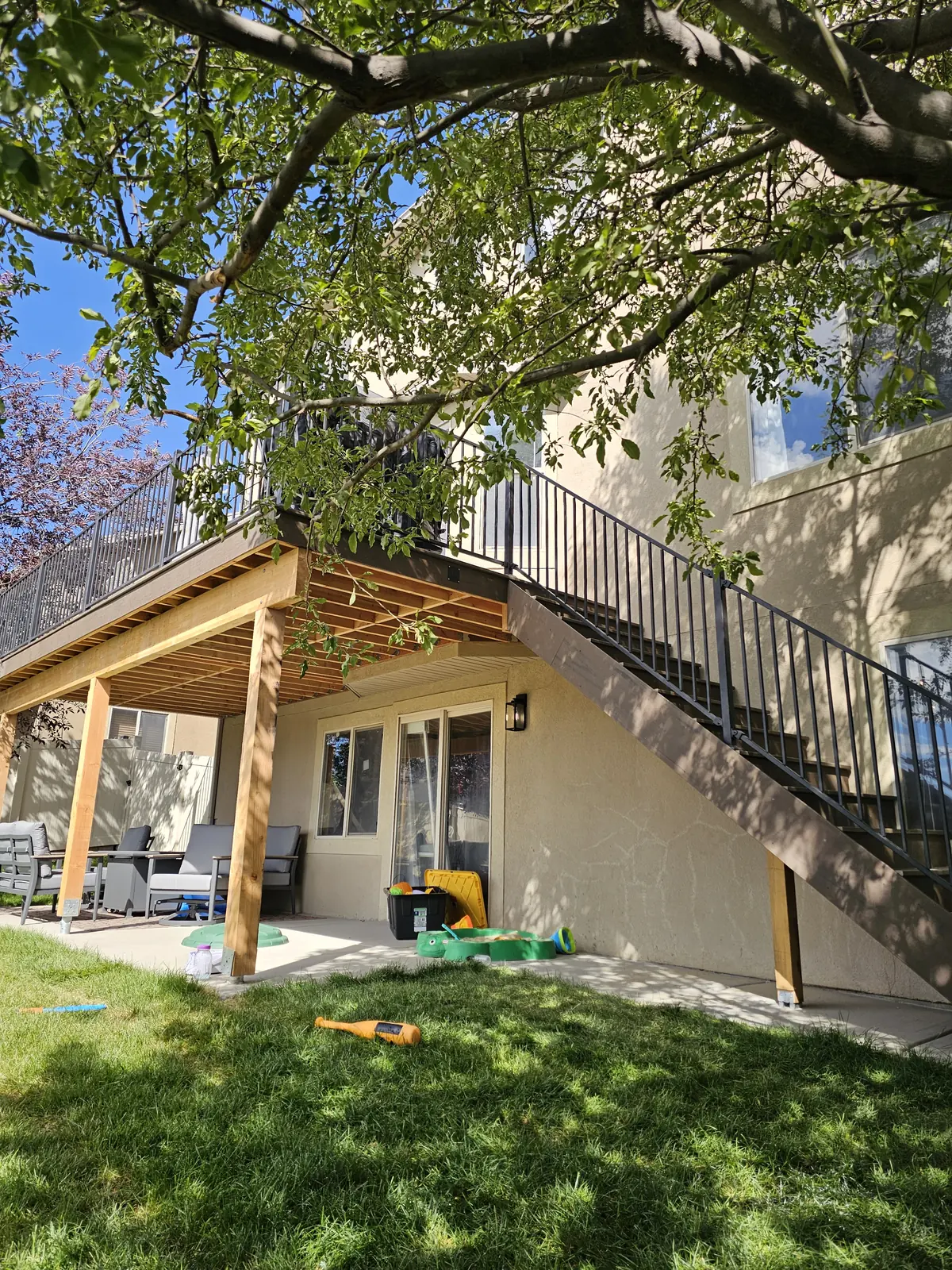 Side stairs with black railing down from a second-story deck
