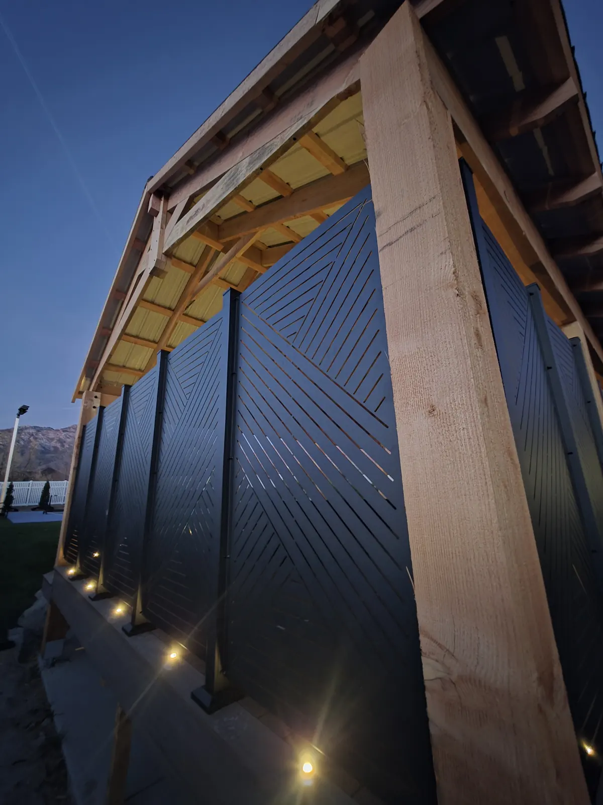 Black HideAway privacy panels between rough-sawn timber posts with deck lights
