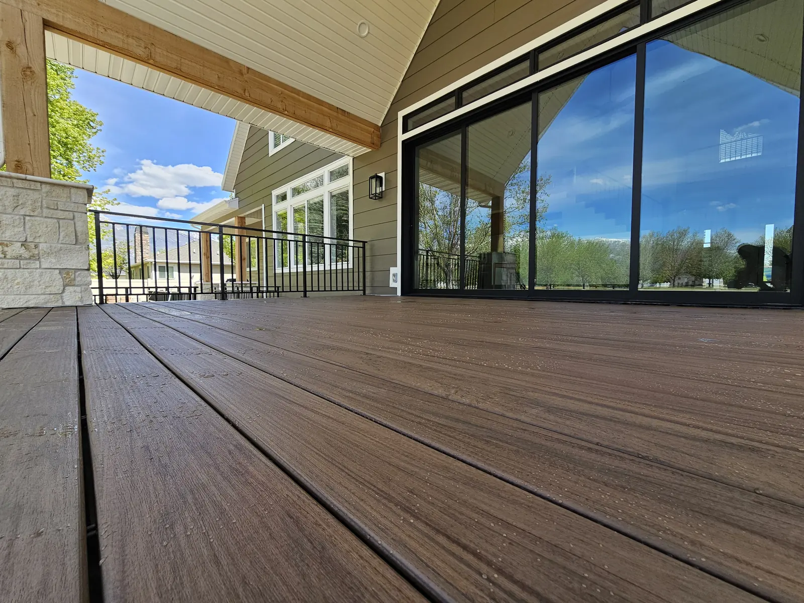 Low view across TimberTech Legacy Pecan deck boards toward sliding doors