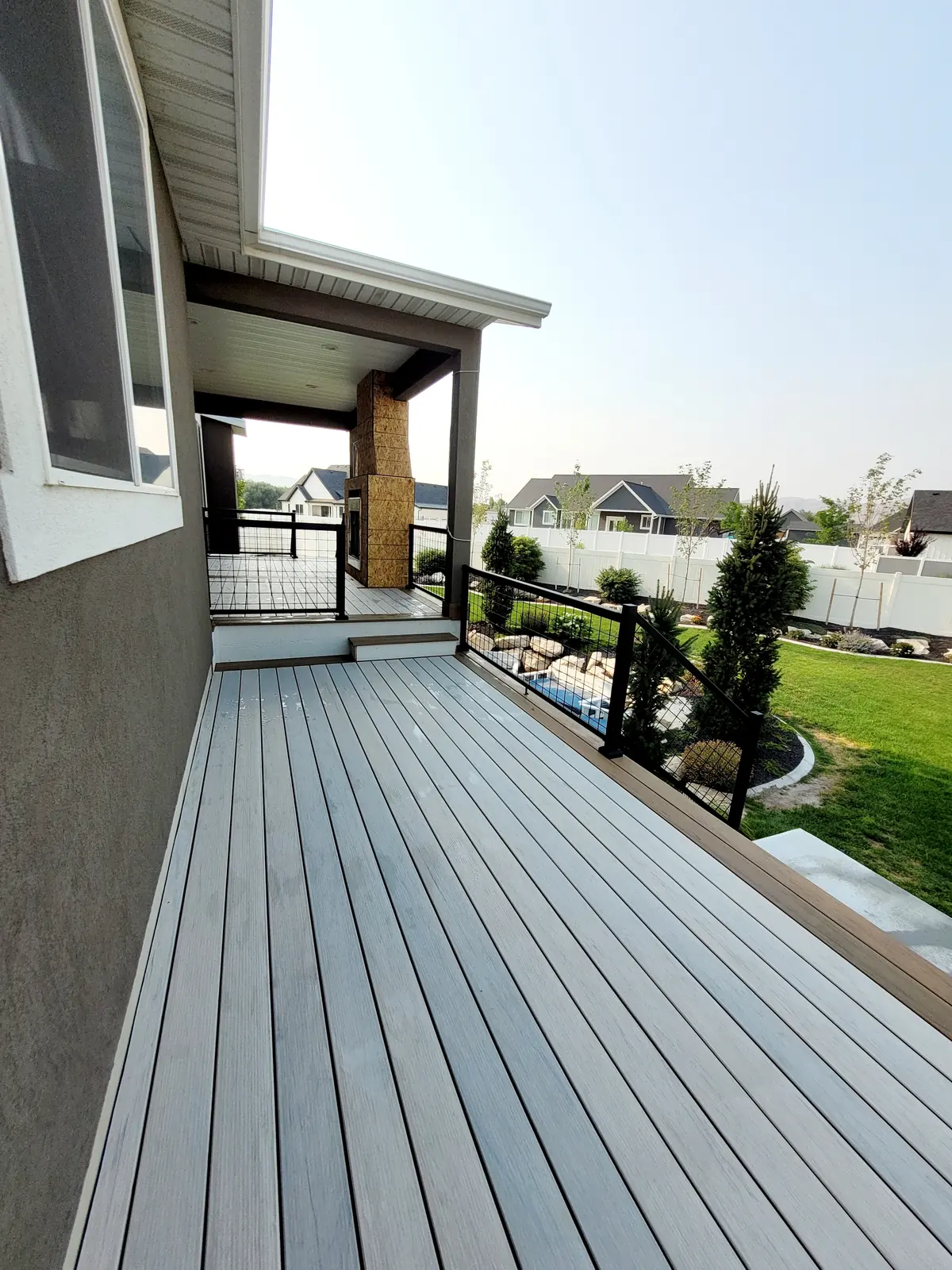 Composite deck walkway with railing above a landscaped yard
