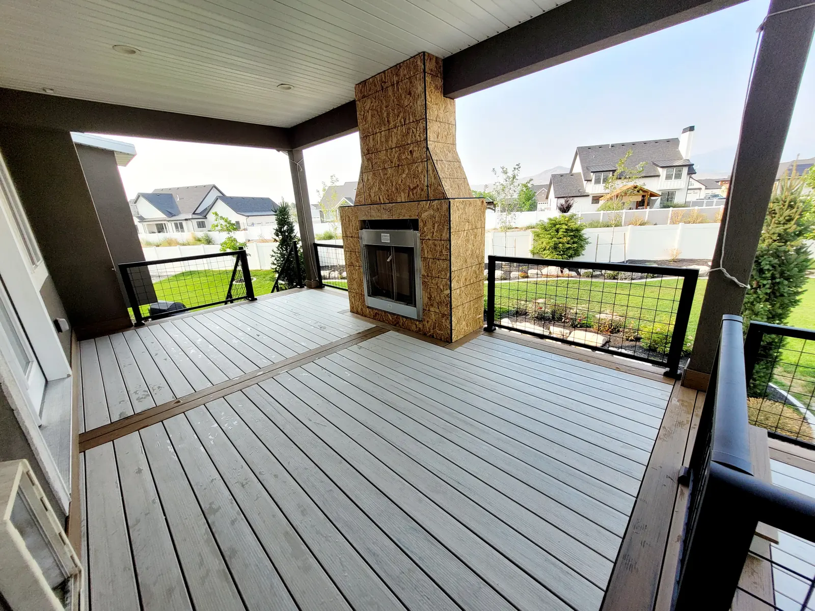 Outdoor fireplace on a covered composite deck