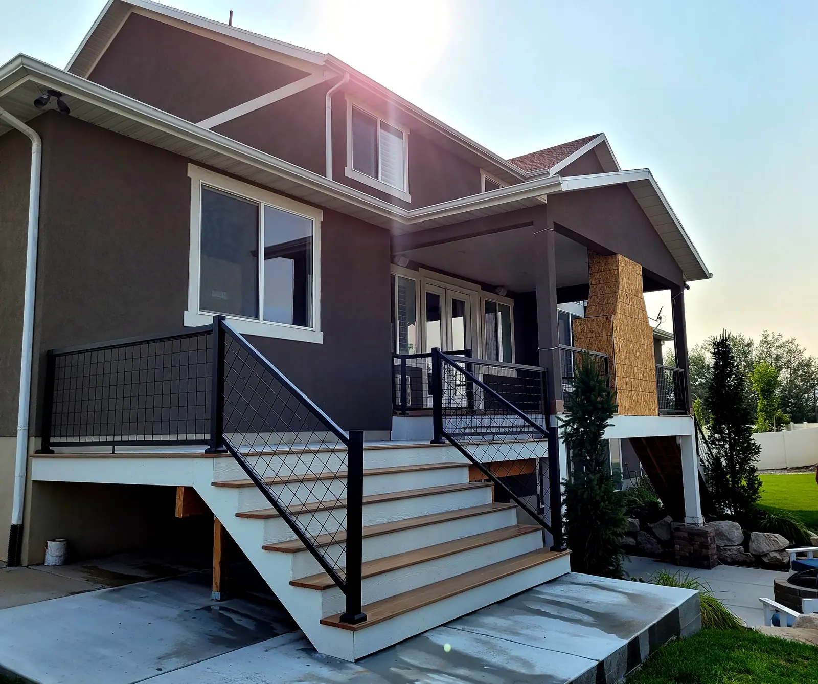 Covered composite deck with a fireplace built by TC Decks in Lehi