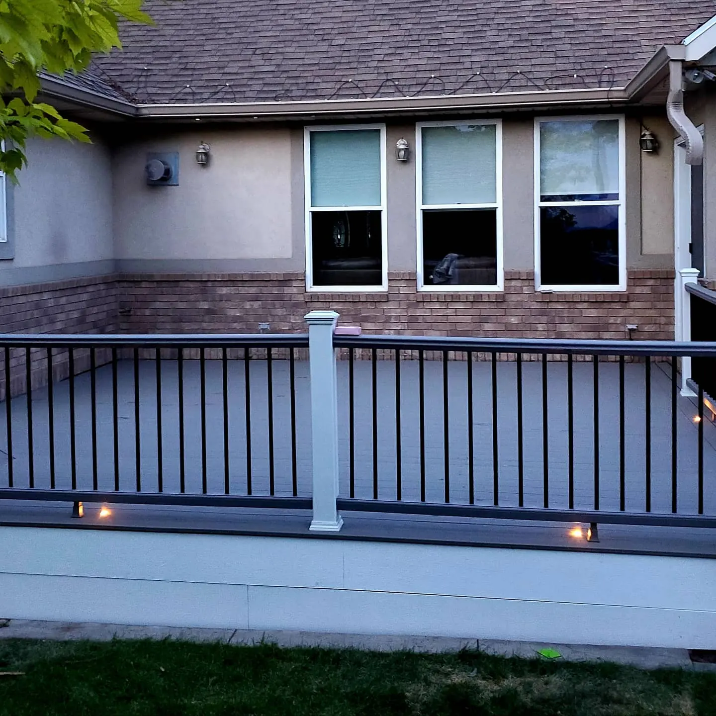 Trex composite railing with white posts, black balusters and under-rail lights