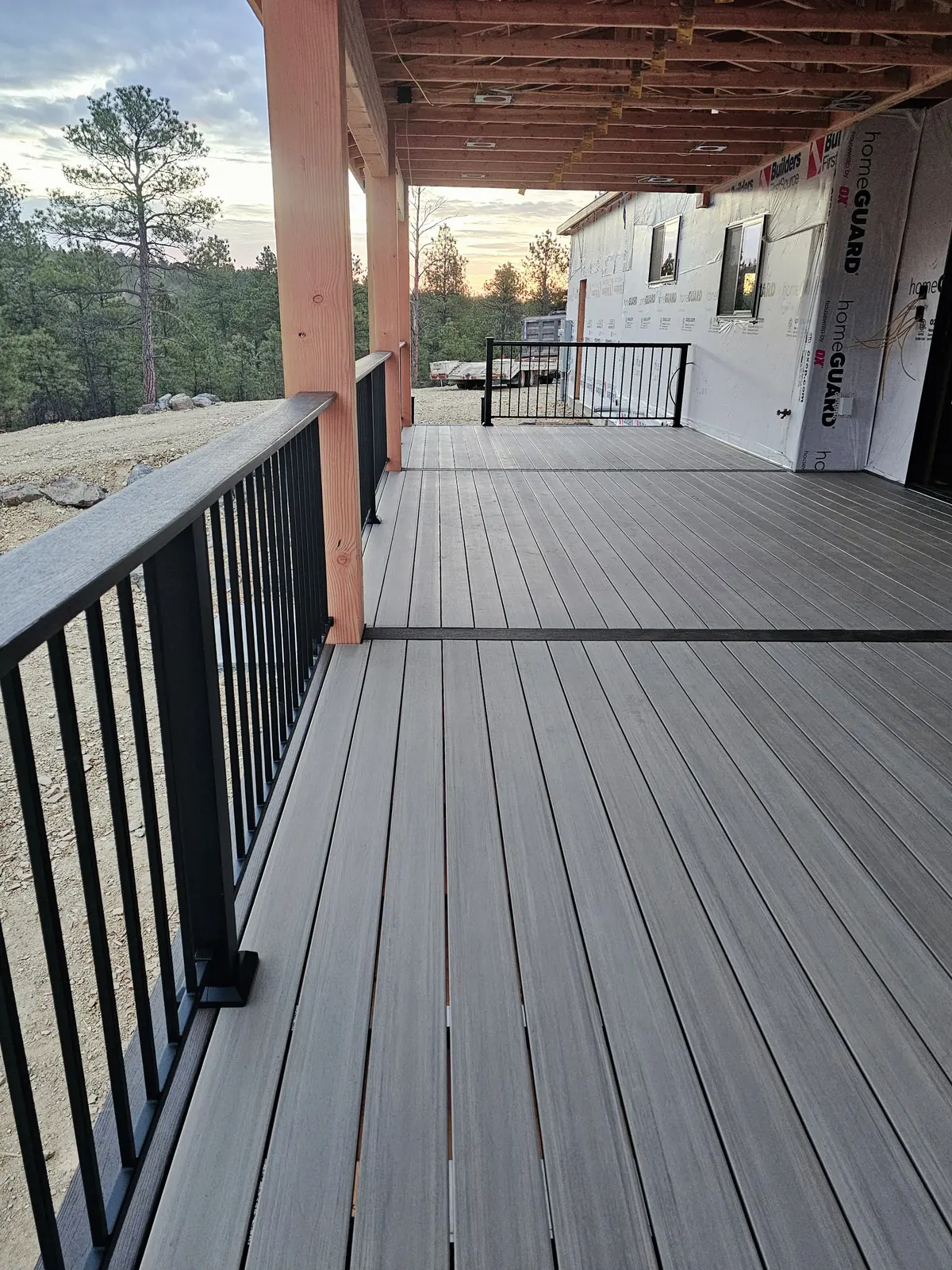 Long run of black Fortress steel railing along a covered TimberTech American Walnut deck