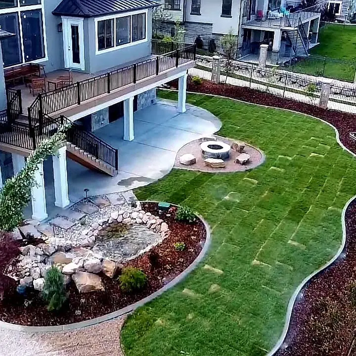 Aerial view of a Tiger Wood deck with stairs down to a landscaped yard and fire pit