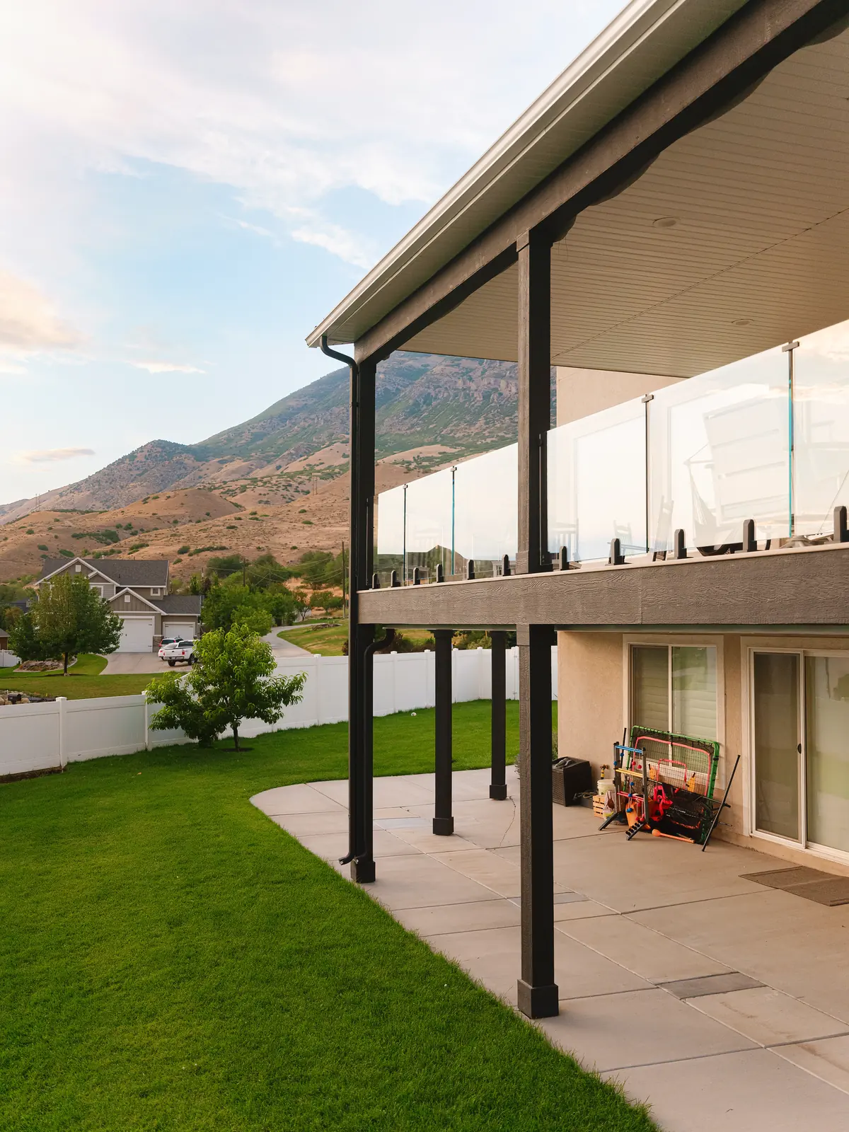 Covered TimberTech French White Oak deck with IG frameless glass railing in the Pleasant Grove foothills