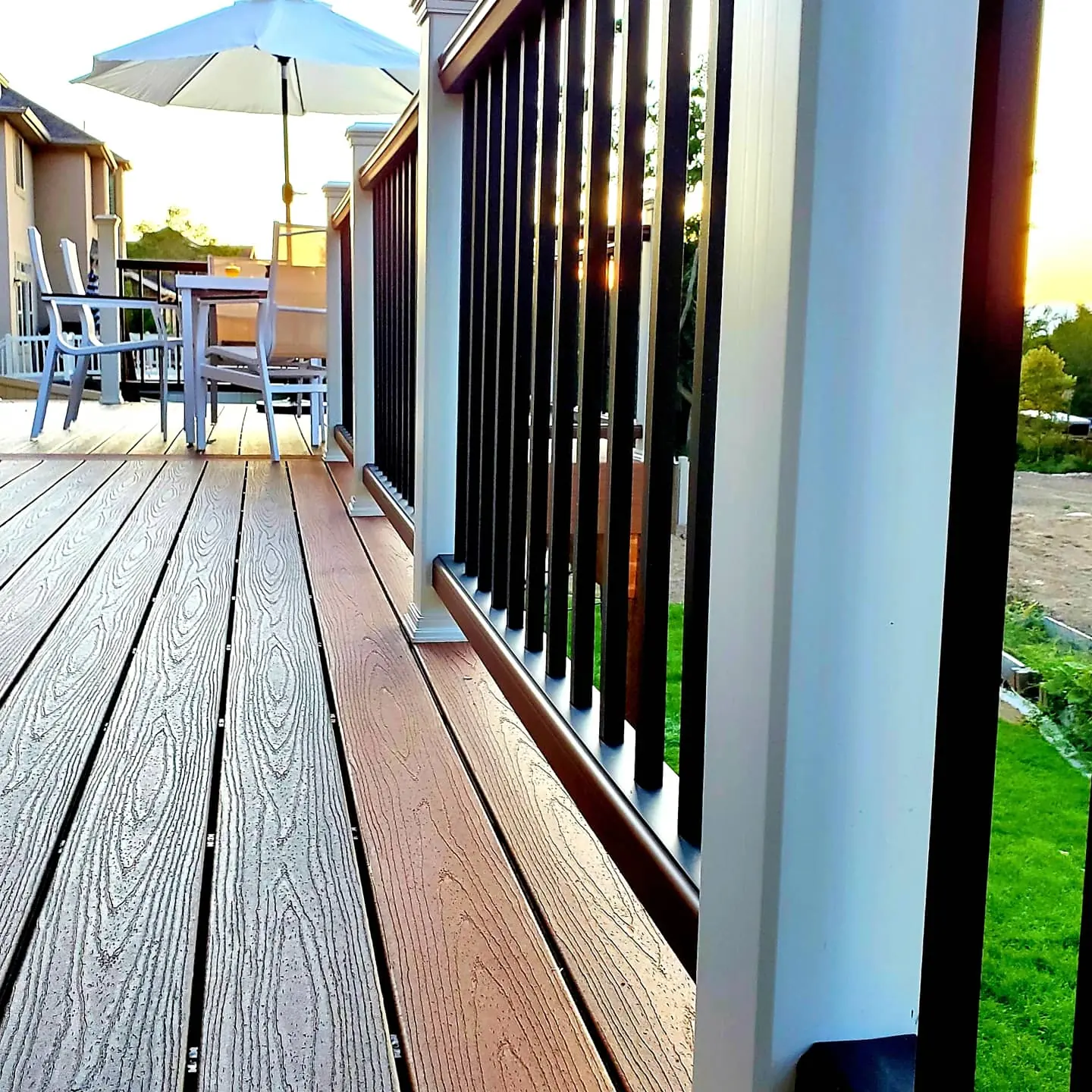 Close-up of Trex deck boards with a contrasting border and white railing posts