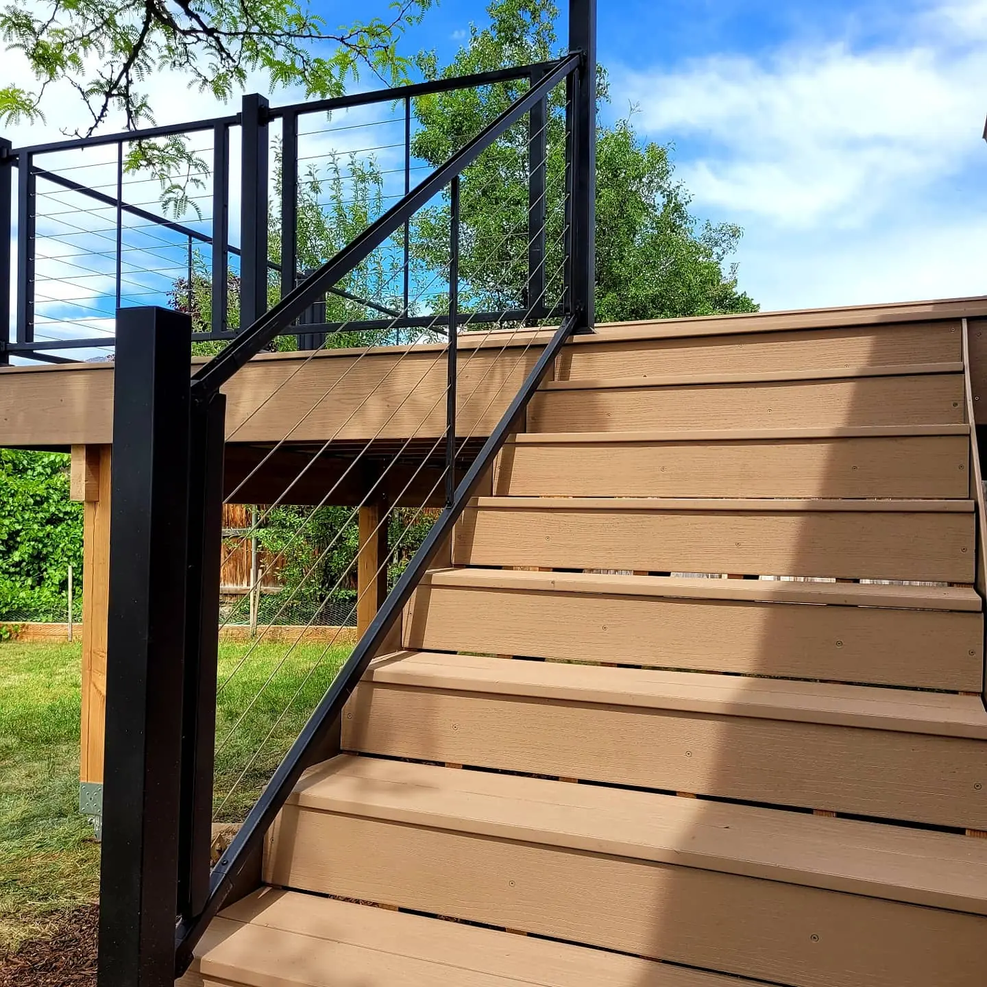 Composite deck stairs with black cable railing in Sandy