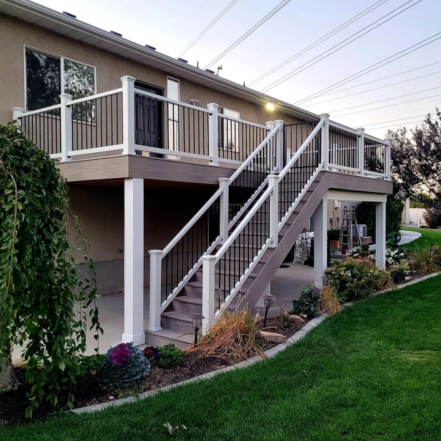 Second-story composite deck with white railing and stairs in Sandy, Utah