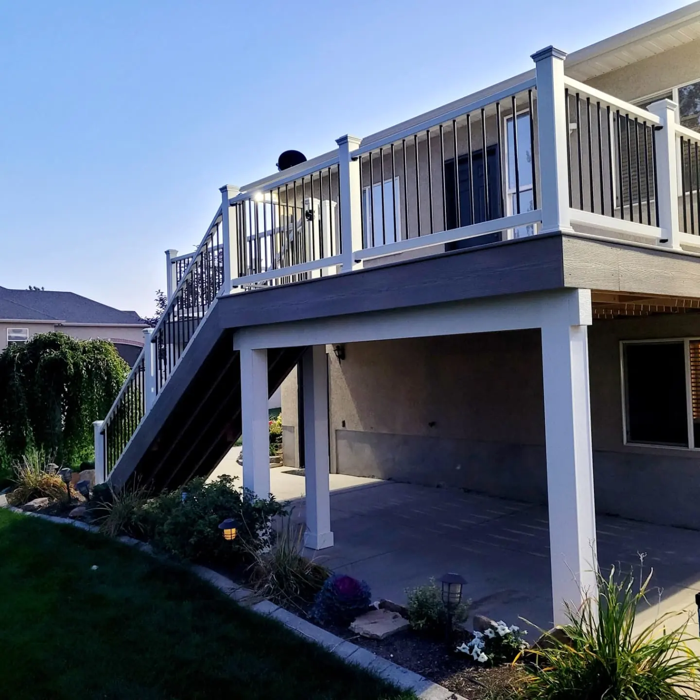 Second-story deck over a covered patio with white wrapped posts