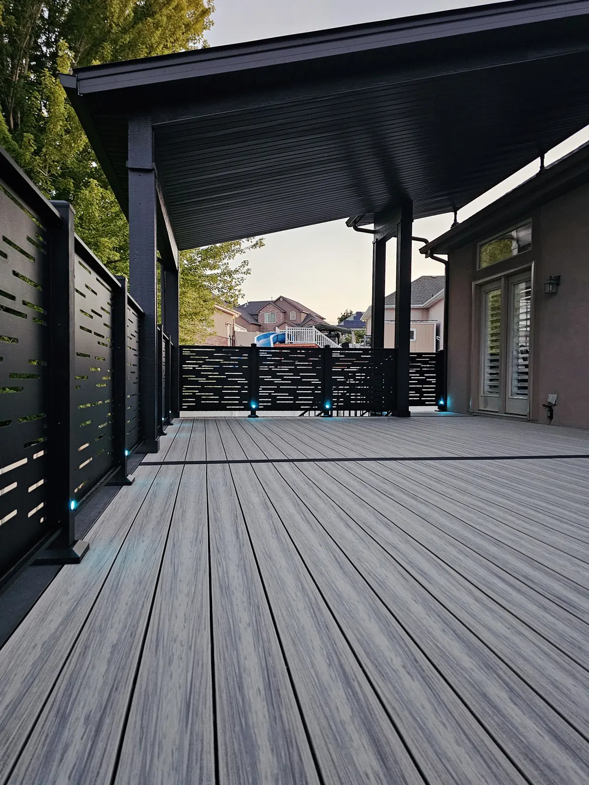Black privacy railing panels and post lights on a covered deck