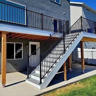 White staircases by TC Decks lead to beautifully arranged patio areas.