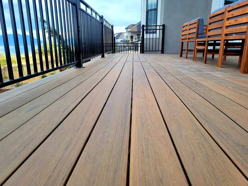 Masterful deck design by TC Decks includes benches and detailed wooden floors.