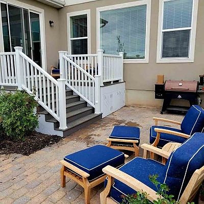 Patios designed by TC Decks pop with blue chairs for added color.